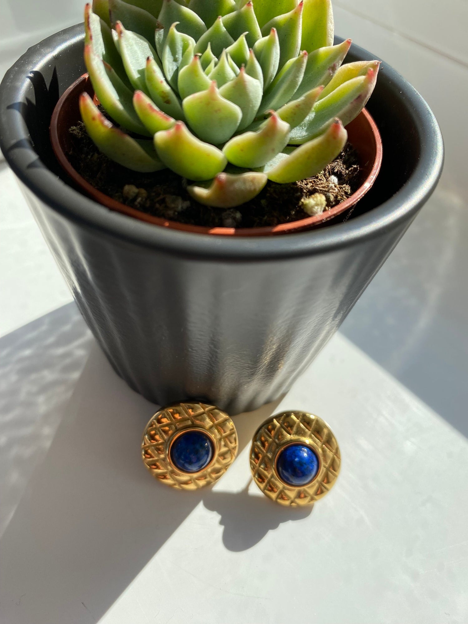Timeless 80s style earrings in gold tone metal and navy blue centerpiece.