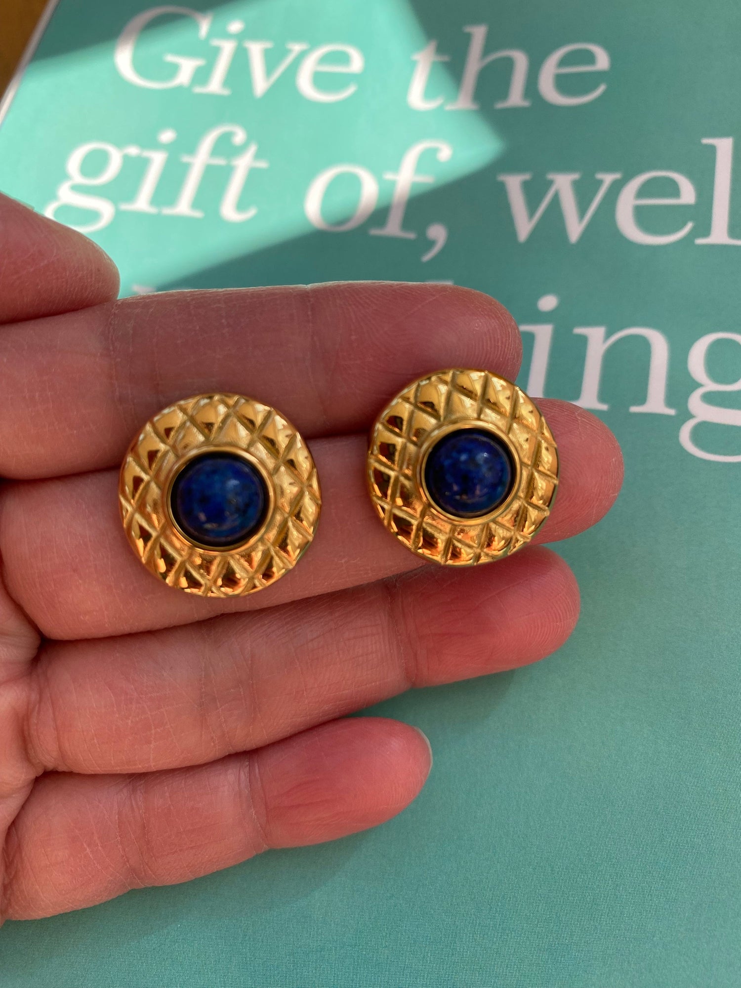 Bold vintage inspired gold earrings featuring a navy enamel or gemstone centerpiece.