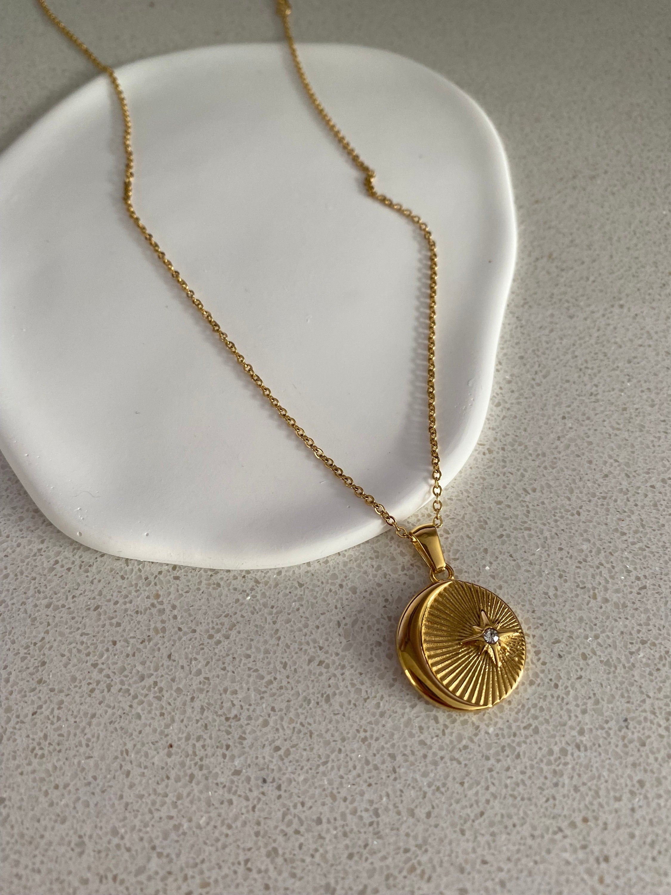 sun and moon zircon pendant necklace with gold coin design  on neutral background