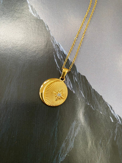 Close up of gold coin sunburst necklace with zircon center stone