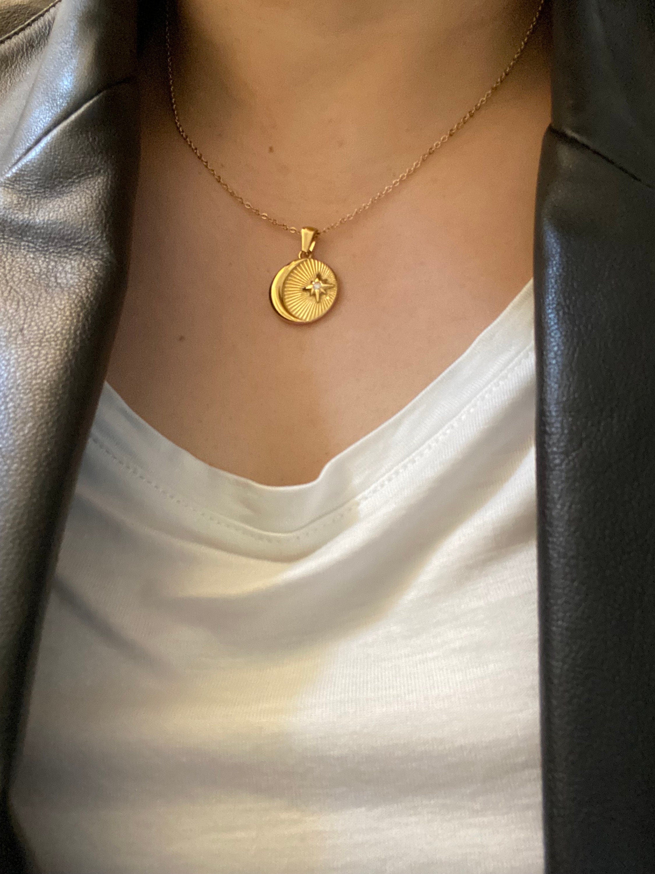 Model wearing layered gold sun and moon necklace